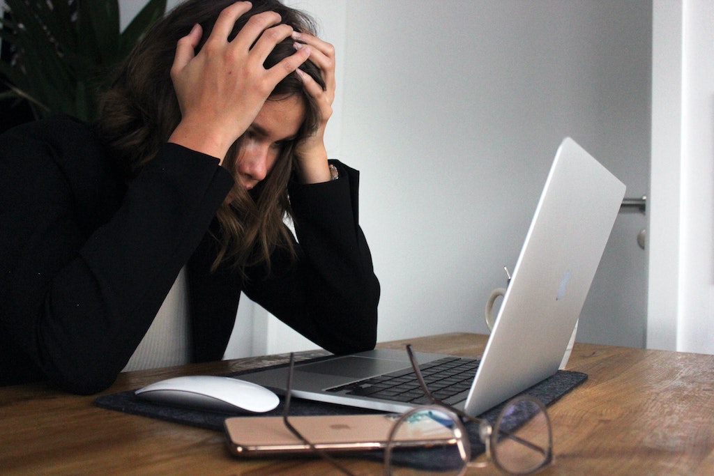 UPS Sendungsverfolgung aktualisiert nicht. Frustrierte Frau vor Laptop.